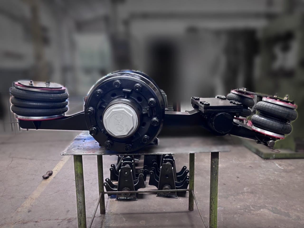 Eje trunnion neumático visto de costado, sobre el banco del taller